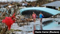 Женщины идут мимо домов, разрушенных ураганом «Дориан». Марш-Харбор, Багамские острова, 3 сентября 2019 года.