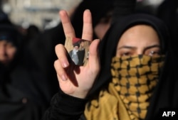 Иранская студентка с маленьким портретом аятоллы Хаменеи