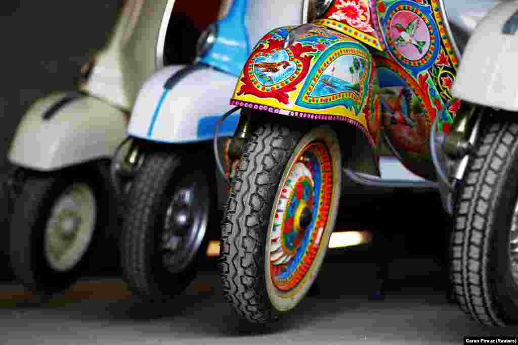 Ярко раскрашенный скутер Vespa в ремонтной мастерской в Исламабаде.