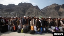 Afghan citizens wait to cross into their home country at the border post in Torkham on March 7.