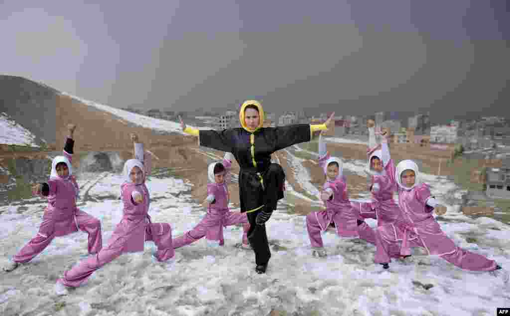 Afghan members of a Wushu martial arts group led by trainer Sima Azimi (center) pose for a photograph at the Shahrak Haji Nabi hilltop overlooking Kabul (AFP/Wahil Kohsar)