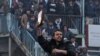 An Afghan demonstrator holds a copy of a half-burned Koran, allegedly set on fire by U.S. soldiers, at the gate of Bagram air base during a protest against Koran desecration at Bagram in February.