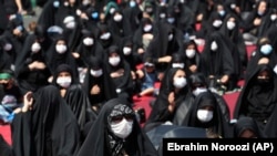 Iran Virus Outbreak Ashoura -- People wearing protective face masks to help prevent spread of the coronavirus mourn during an annual ceremony commemorating Ashoura, the anniversary of the 7th century death of Imam Hussein, a grandson of Prophet Muhammad, 