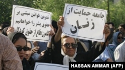 Iranian women brandish banners calling for the improvement of women's rights during a protest in Tehran. File photo.