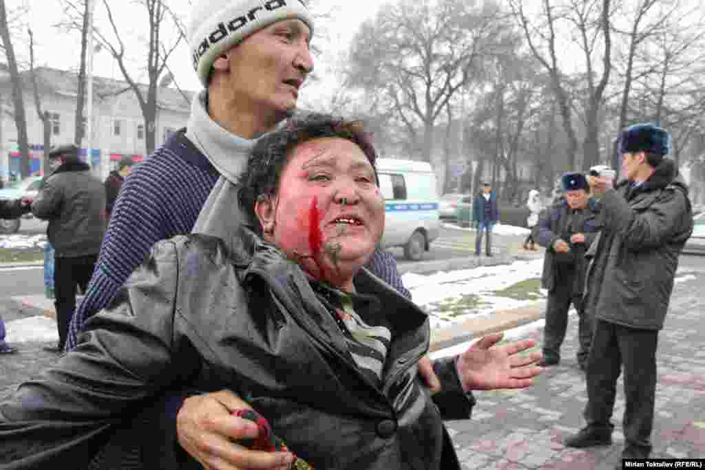 A Kyrgyz woman, Zhyparkan Omurova, tries to commit self-immolation in front of the parliament building in Bishkek to protest a court judgment against her son. (RFE/RL/Mirlan Toktaliev)