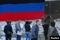 A pro-Russian armed man stands guard as local residents wait near the mayor's office in Slovyansk, Ukraine, on April 25.