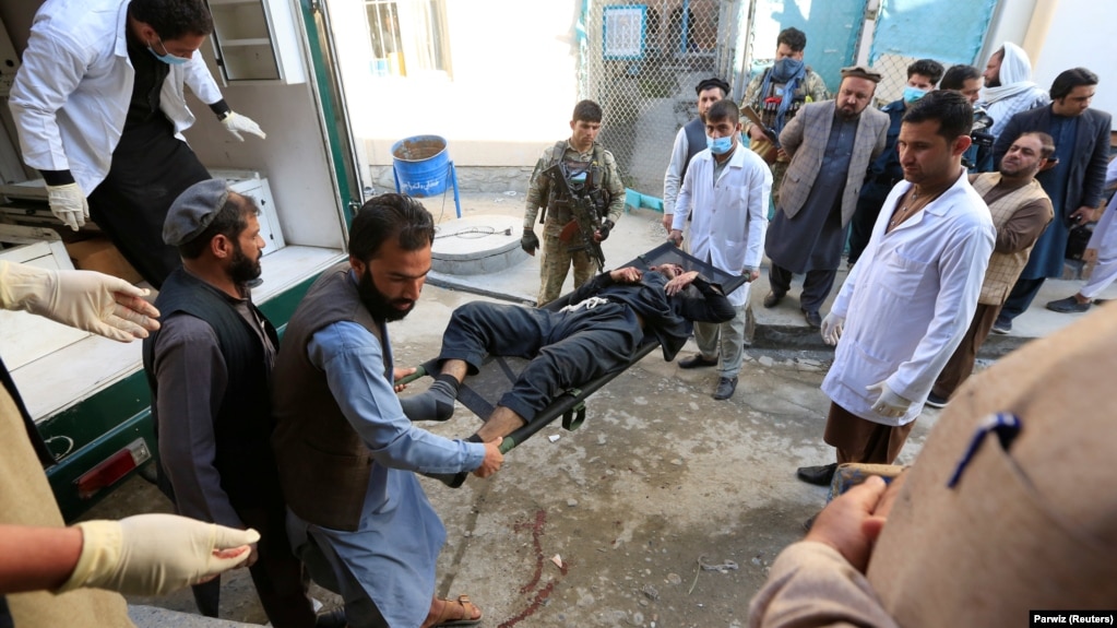 Afghan men carry a victim of the attack in Jalalabad on March 6.