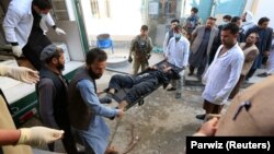 Afghan men carry a victim of the attack in Jalalabad on March 6.