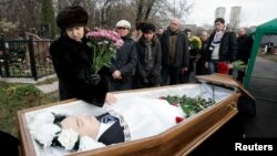 Natalia Magnitskaya (left), mother of Sergei Magnitsky, grieves over her son's body during his funeral at a cemetery in Moscow in November 2009.