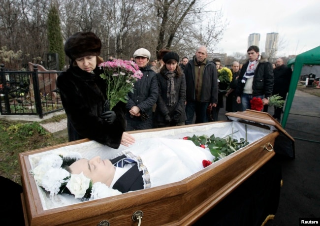 Nataliya Magnitskaya (majtas), nëna e Sergei Magnitskyt, duke vajtuar afër trupit të djalit të saj në ceremoninë e varrimit.
