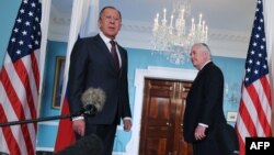 U.S. Secretary of State Rex Tillerson (right) watches as Russian Foreign Minister Sergei Lavrov reacts to a reporter's question after posing for photos in the Treaty Room of the State Department in Washington in May.