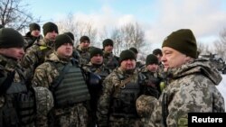 Украинский президент Петр Порошенко встречается с солдатами на оборонительных укреплениях во время поездки в зону военного конфликта с поддерживаемыми Москвой сепаратистами в декабре этого года.
