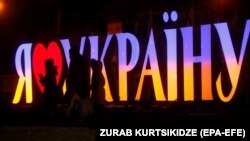 Ілюстраційне фото. Люди проходять повз освітлений знак «Я люблю Україну» на майдані Незалежності в Києві, 4 лютого 2022 року