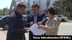 Представитель акимата Астаны (в центре) передает подавшим заявку на проведение митинга 21 мая «по земельному вопросу» письменный отказ. Астана, 18 мая 2018 года.