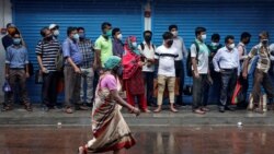 Люди в масках в ожидании автобуса в индийском городе Калькутта во время пандемии коронавируса.