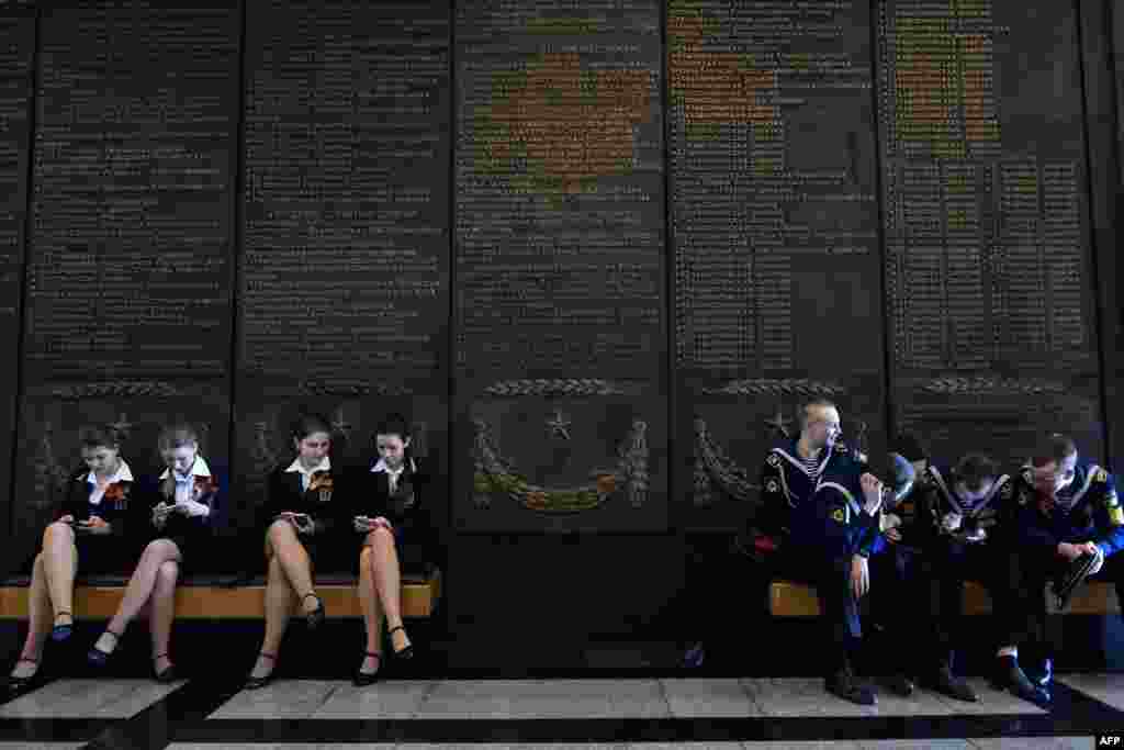 Schoolgirls and navy cadets rest on banquettes at the Museum of the Great Patriotic War at Poklonnaya Gora in Moscow. Russia celebrates the 70th anniversary of the 1945 victory over Nazi Germany on May 9. (AFP/Kirill Kudryavtsev)