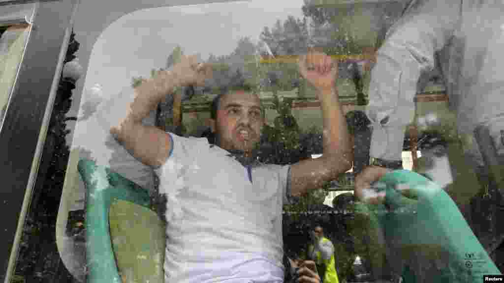 A detained Azerbaijani opposition supporter shouts inside a police bus during an antigovernment protest in central Baku on May 21 just before the Eurovision Song Contest &nbsp;was due to be held in the city. (Reuters/David Mdzinarishvili)