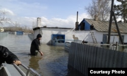 Спасатели проверяют дома в затопленном паводками селе Садовом Бухар-Жырауского района Карагандинской области. 16 апреля 2015 года.