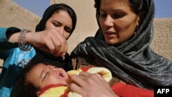 Дәрігер әйел полиомиелитке қарсы вакцинаны баланың аузына тамызып тұр. Ауғанстан, Кабул, 16 қараша 2009 жыл. 
