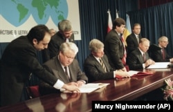 Yeltsin, Clinton, then-President of Ukraine Leonid Kuchma, and British Prime Minister John Major sign the Nuclear Non-Proliferation Treaty during the CSCE summit in Budapest on December 5, 1994.