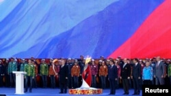 Russian President Vladimir Putin (center) holds a lit Olympic torch during a ceremony to mark the start of the Sochi 2014 Winter Olympic torch relay in Moscow on October 6. The flame fared more poorly at the Kremlin.