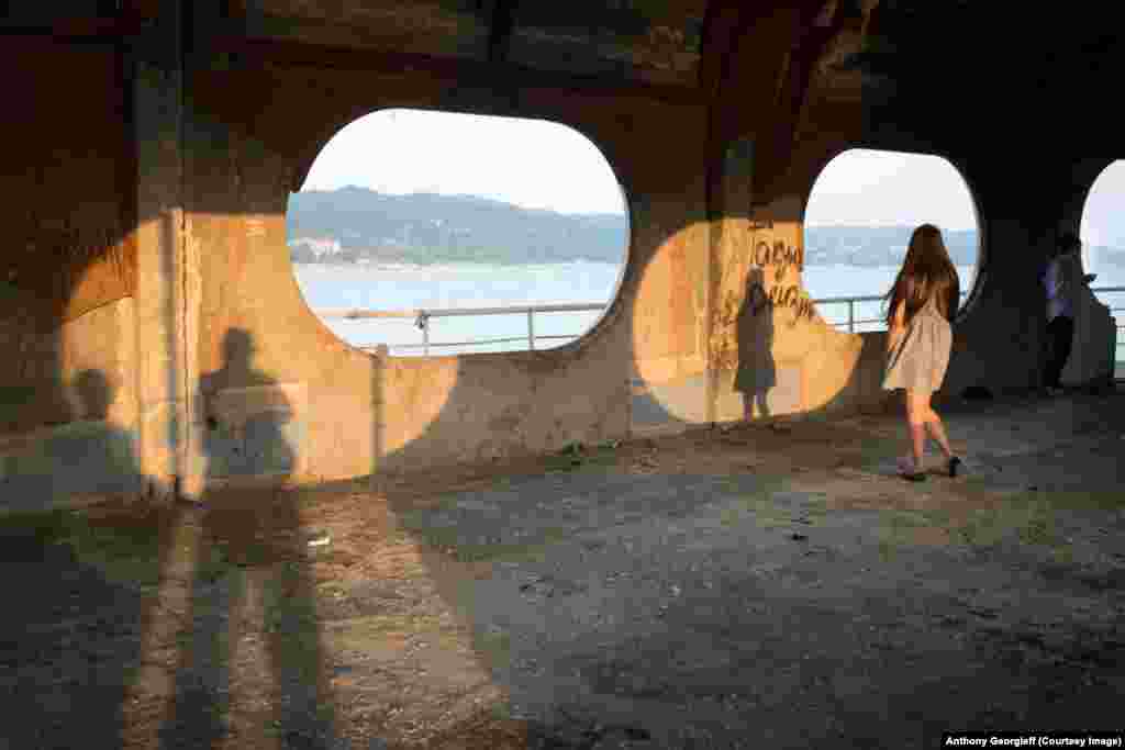 People take an evening stroll through the shell of the Sukhumi Pier. 