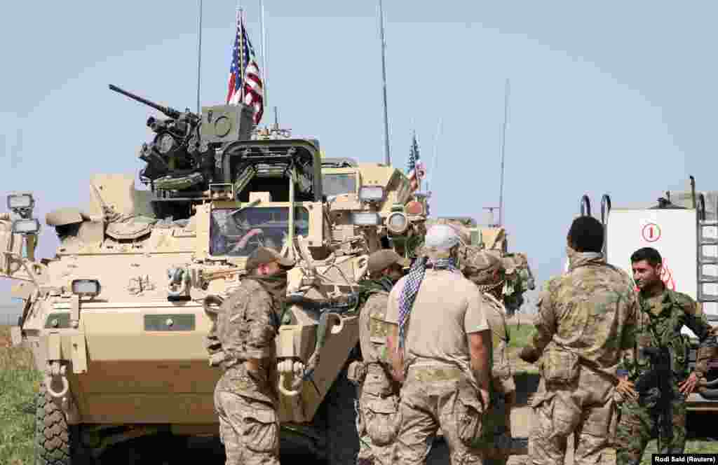 Kurdish fighters from the People&#39;s Protection Units (YPG) chat with members of U.S. forces in the Syrian town of Al-Darbasiyah in April 2017. The stated U.S. mission in Syria includes training and advising rebel forces fighting Islamic State (IS) militants.&nbsp;