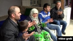 В семье таджиков благославляют своего родственника, отправляющегося на заработки в Россию. Кадр видеозаписи.