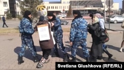 Полиция уводит жительницу Астаны Алтын Червалиеву, которая проводила пикет против сноса ее жилья. 3 апреля 2014 года.