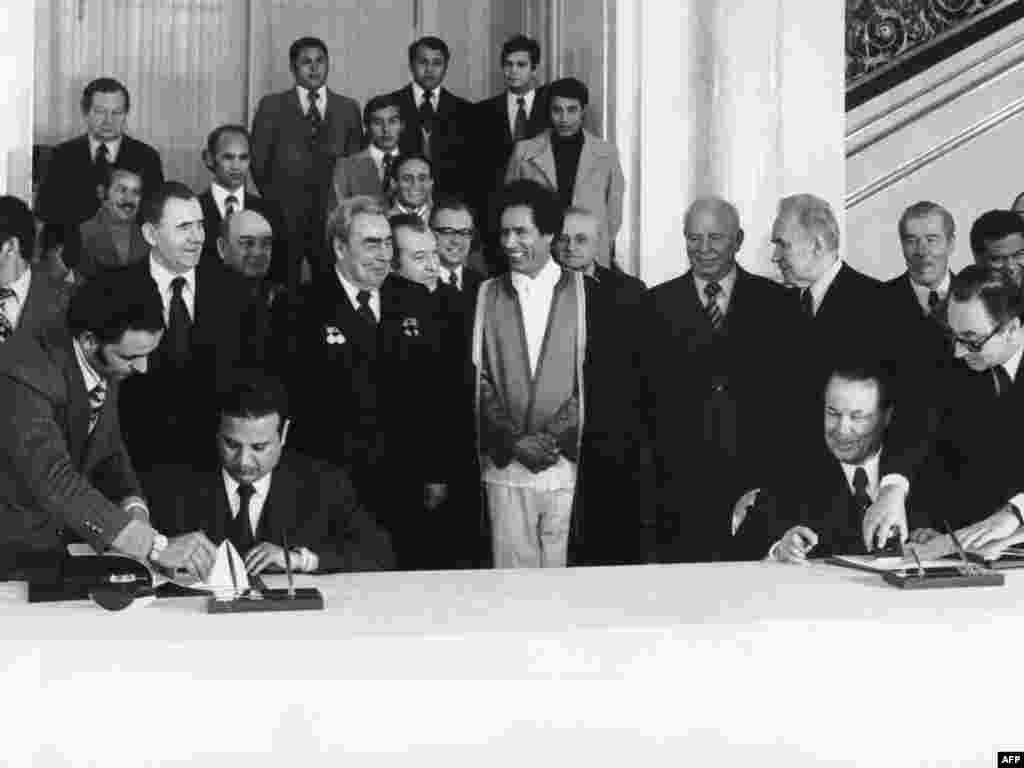 Gaddafi (&icirc;n centru) şi liderul sovietic Leonid Brejnev (la dreapta lui Gaddafi) &icirc;n timpul unei ceremonii de semnare a unor acorduri la Moscova &icirc;n decembrie 1976.