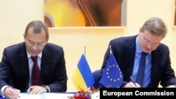 Ukrainian Deputy Prime Minister Andriy Klyuyev (left) and EU Enlargement Commissioner Stefan Fuele sign documents at EU headquaretrs in Brussels.