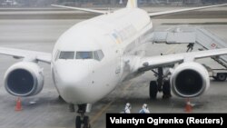 Співробітники аеропорту одягнені у захисні костюми, щоб дезінфікувати літак МАУ, «Бориспіль», Україна