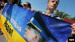 Ukrainian activists hold a banner saying "Ukraine needs Nadiya" and a Nadiya Savchenko portrait during a rally demanding the release of the Ukrainian officer in front of the Russian Embassy in Kyiv last month.