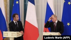 Putin (right) and Macron give a joint press conference following talks outside St. Petersburg in May 2018.