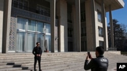 In this Jan. 15, 2019 photo, men take pictures while visiting Niavaran Palace, now a museum, that was the primary and last residence of late Shah Mohammad Reza Pahlavi and his family prior to leaving Iran for exile in 1979.