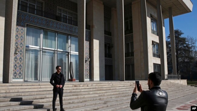 In this Jan. 15, 2019 photo, men take pictures while visiting Niavaran Palace, now a museum, that was the primary and last residence of late Shah Mohammad Reza Pahlavi and his family prior to leaving Iran for exile in 1979.