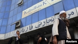 People walk past Kabul Bank branch in Kabul