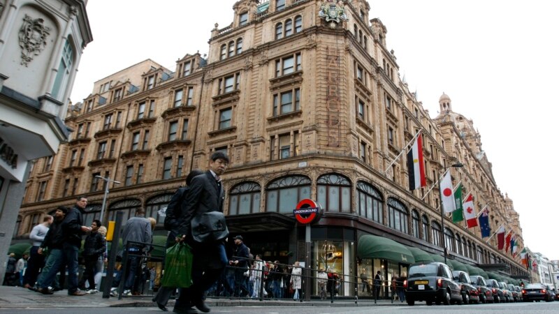 Пешеходы идут по улице рядом с дорогим лондонским магазином Harrods.