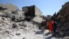 Iraqi civilians and rescue workers inspect the damage in Mosul following an air strike on March 26.