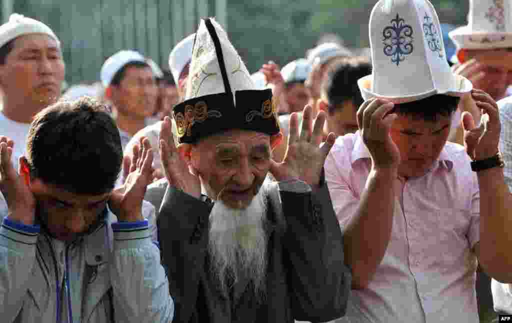 Kyrgyz men pray on the first day of Eid al-Fitr on a square in central Bishkek. 