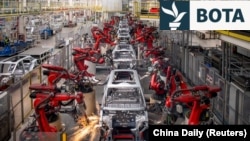 Krahët robotikë montojnë makina në linjën e prodhimit për automjetet elektrike të Leapmotor në një fabrikë në Kinë, 26 prill 2023.