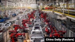 Brațe robotizate asamblează mașini pe linia de producție a vehiculelor electrice Leapmotor într-o fabrică din Jinhua, provincia Zhejiang, China, 26 aprilie 2023.