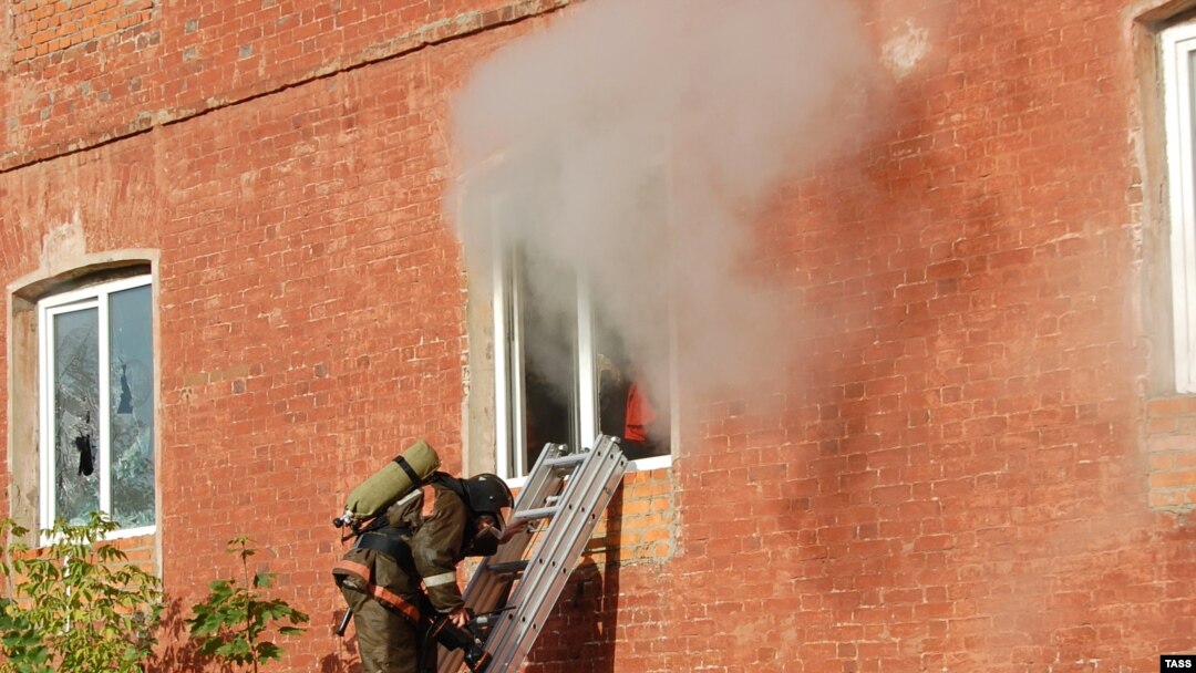 A firefighter stands on a ladder by a window of a garment factory on fire in the town of Yegoryevsk, southeast of Moscow, on September 11.