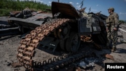 Український військовий біля зруйнованого танка поблизу Роботиного, Запорізька область, 25 серпня 2023 року