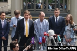 Lawyers Maksim Olenichev (from left), Yevgeny Smirnov, Ilya Novikov, Ivan Pavlov, Vladimir Voronin, and Valeria Vetoshkina speak with the media near the Moscow City Court on June 9 during the case against Navalny's organization.