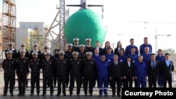 Chinese and Pakistani navy officials pose during a ceremony to launch the Ghazi submarine in Wuhan, China, on December 17.