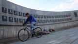 Kosovo -- A youth cycles past the memorial to the victims of the Recak massacre, where forty-five ethnic Albanians were killed by Serbian forces in January 1999, in the village of Recak, September 22, 2016