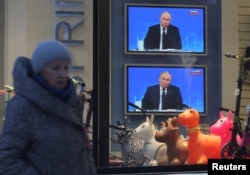 Ekrani u izlozima prodavnica prenose godišnju konferenciju za medija Vladimira Putina na ulicama Sankt Peterburga. 14. decembar 2023.