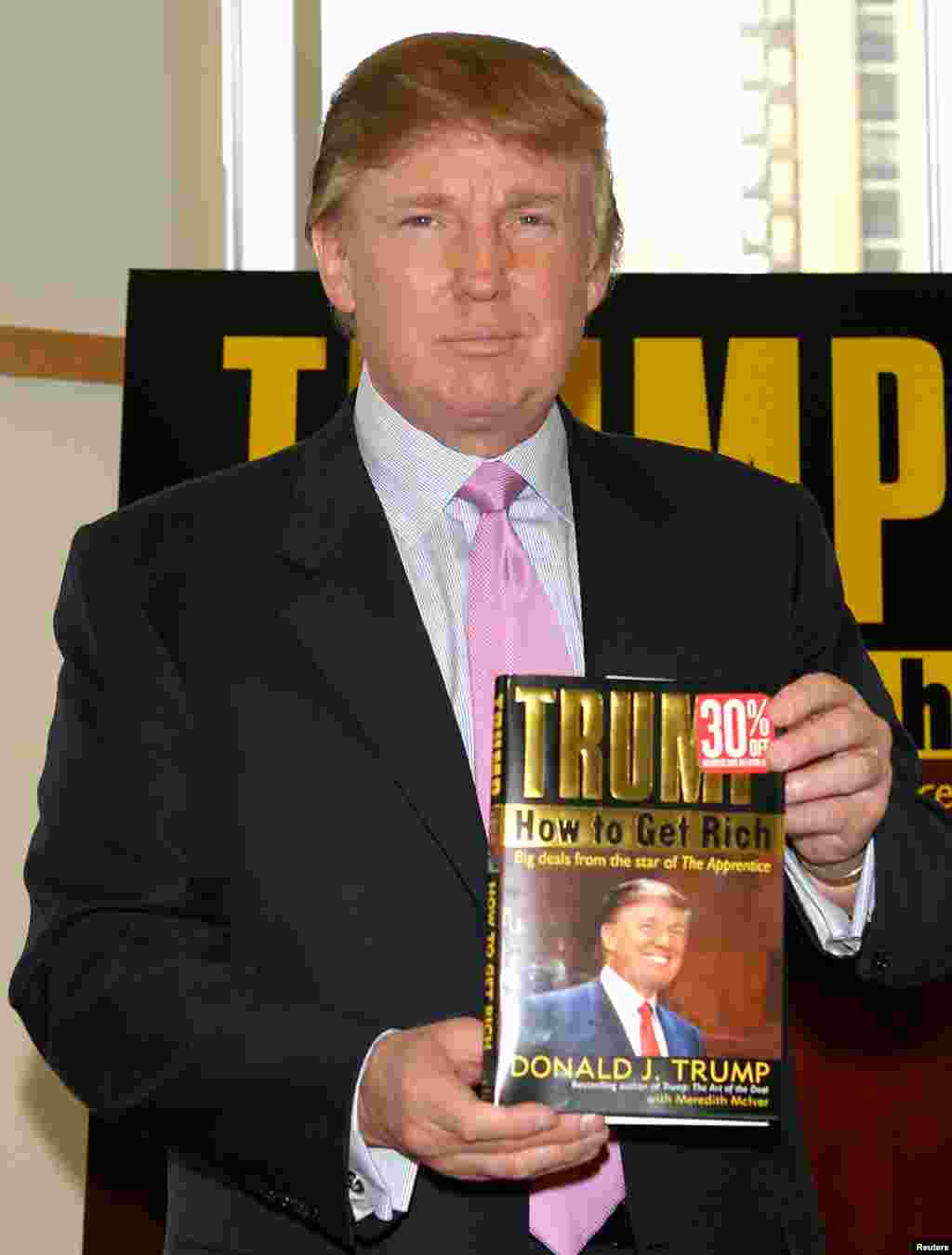 Trump holds a copy of his book, How To Get Rich, in 2004. His 1987 book, The Art Of The Deal, was a best seller that increased his fame.