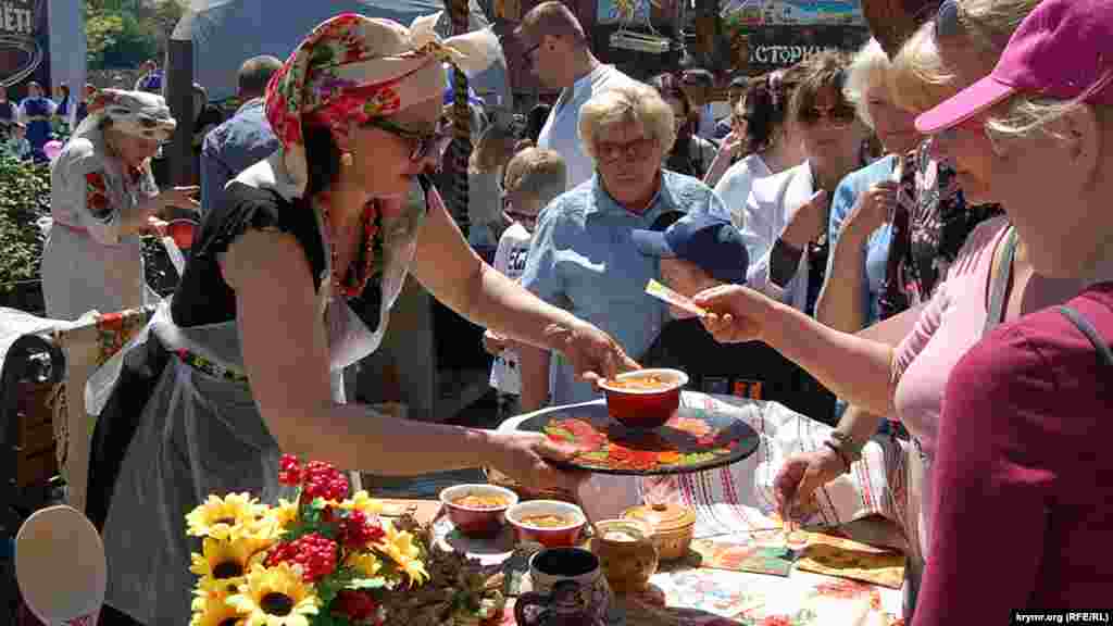 Активист УНКОС Светлана Левон (слева &ndash; в национальном украинском платке и национальной сорочке) раздает уже готовый борщ в обмен на бесплатные таллоны-лукоморчики.